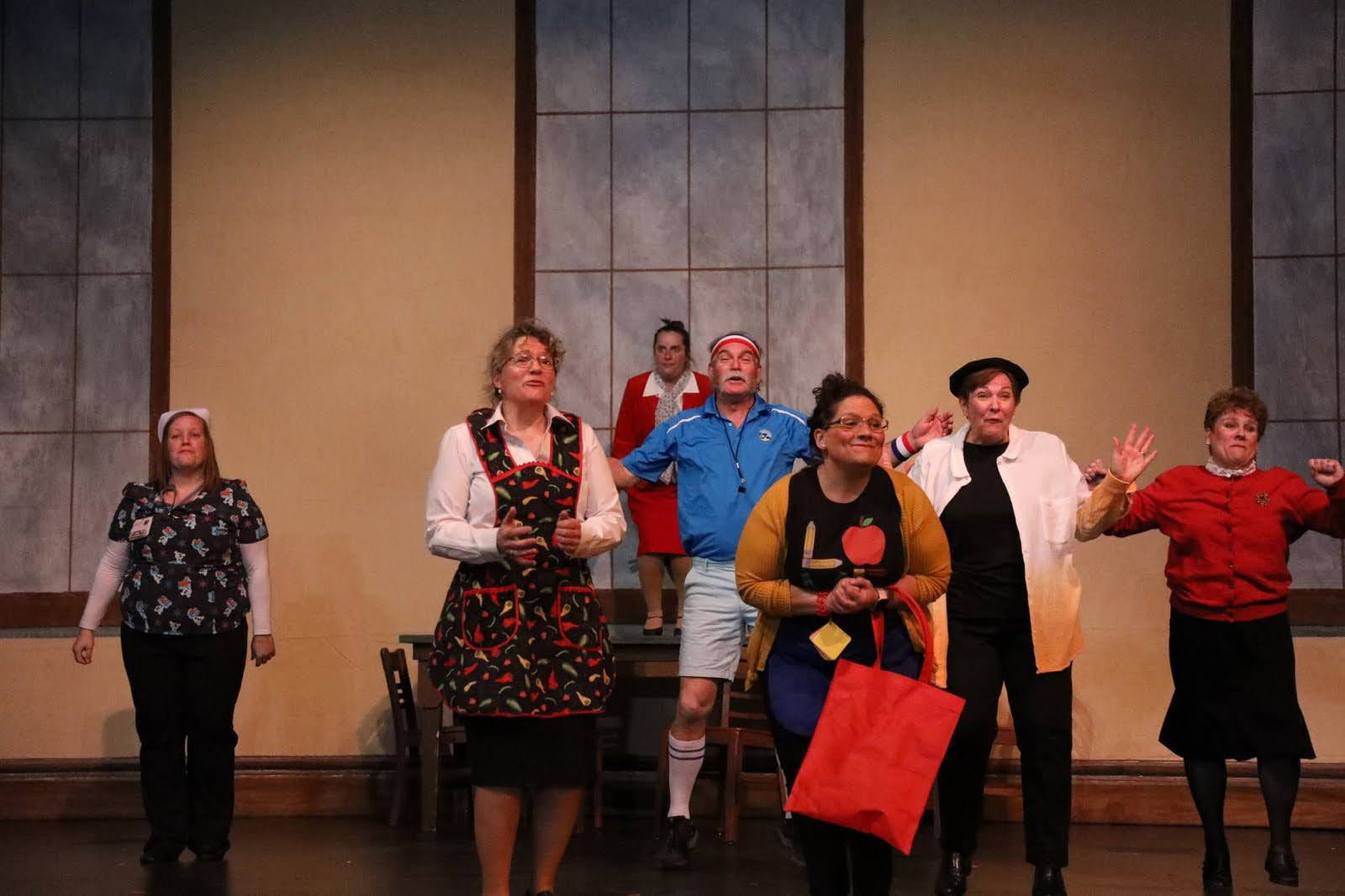 A group of teachers and school staff dance in the teachers lounge.
