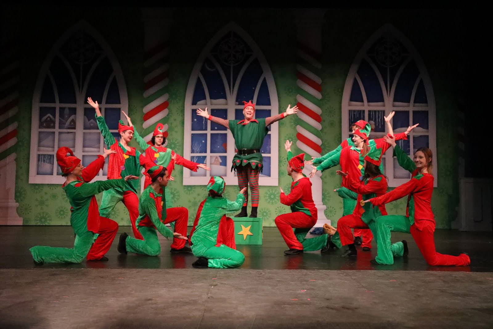 Elves gather in front of windows showing a wintery scene.